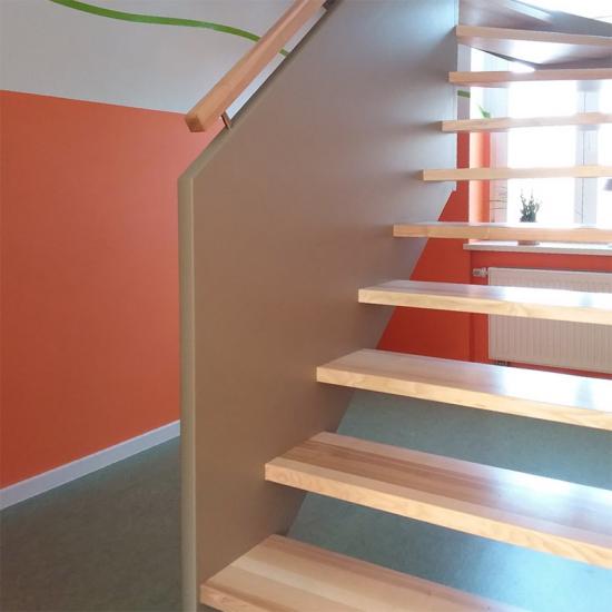 Moderne Treppenanlage mit brüstungshoher Innenwange in Esche-grau