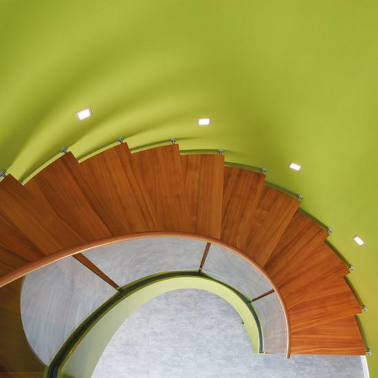 Bogentreppe mit Holzstufen und Glasgeländer von Treppenmeister GmbH