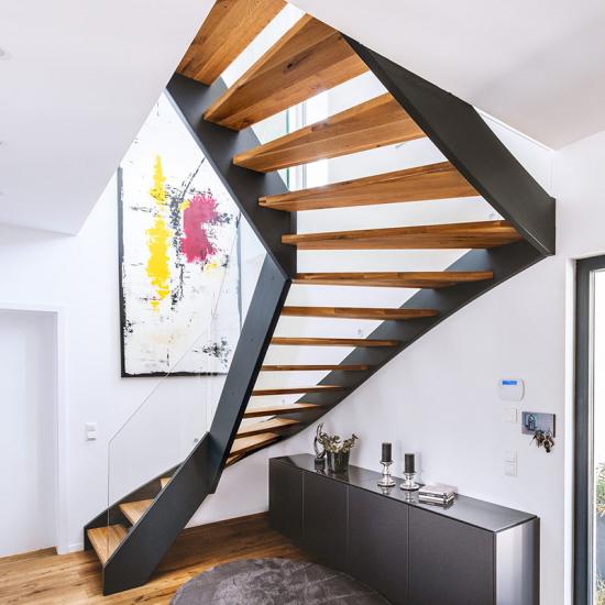 Holzwangentreppe mit grauen Wangen und Glasgeländer von POTRYKUS Treppen-Konzepte